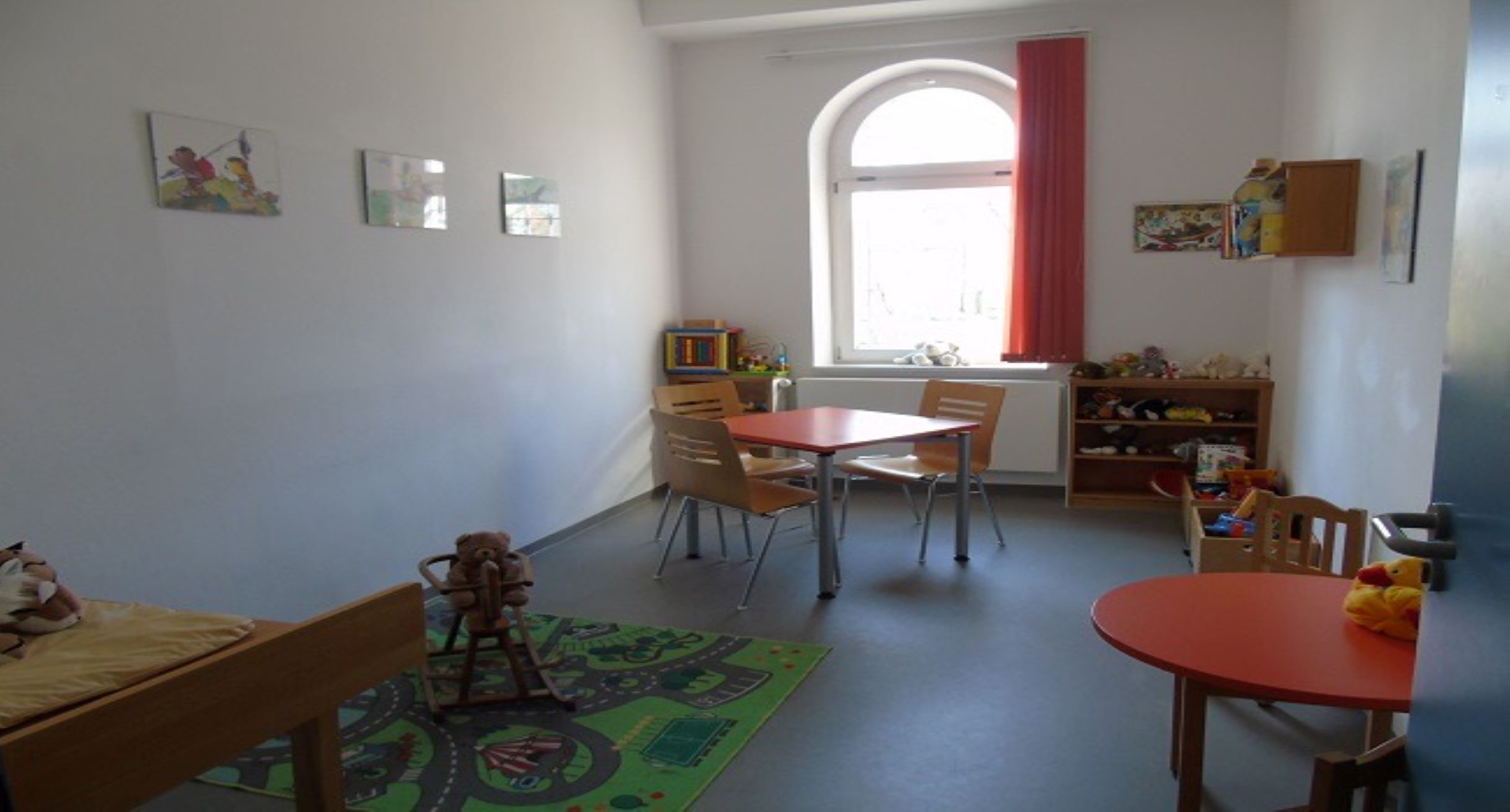 Ein Besucherraum in einer Justizvollzugsanstalt mit vielen Tischen und Stühlen. 